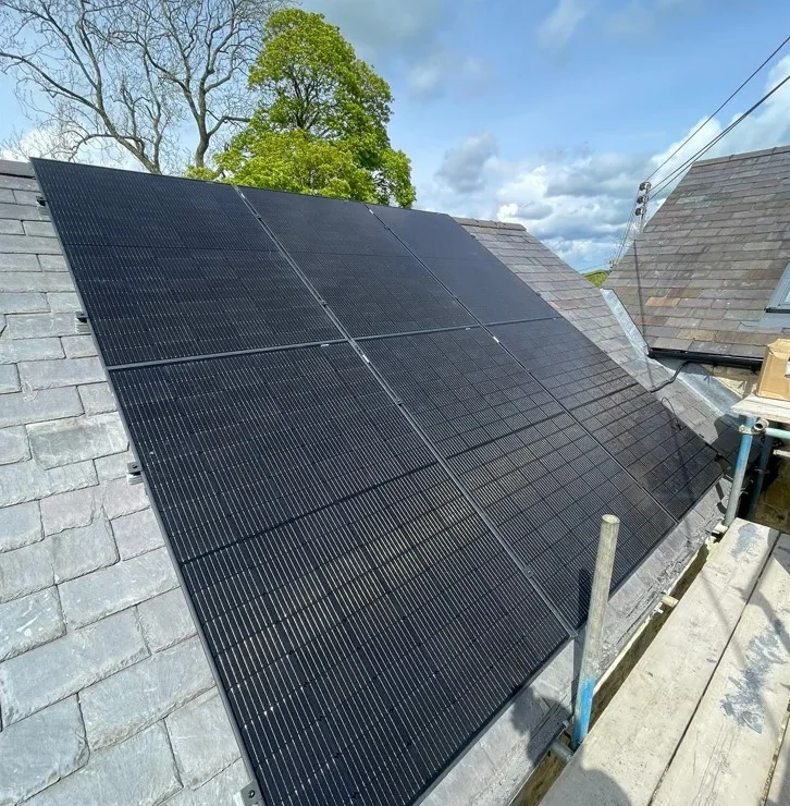 six solar panels on a grey roof, under a blue sky