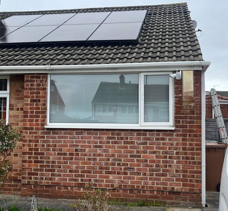 eight solar panels on the roof of a modest bungalow