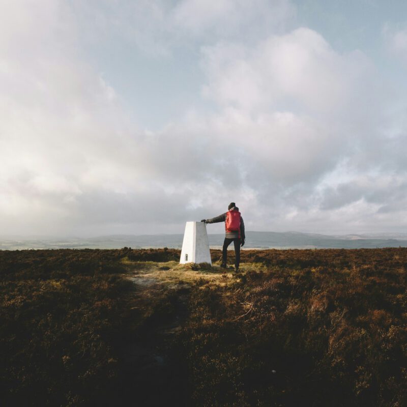 Hiker at the summit of a Northumberland hill