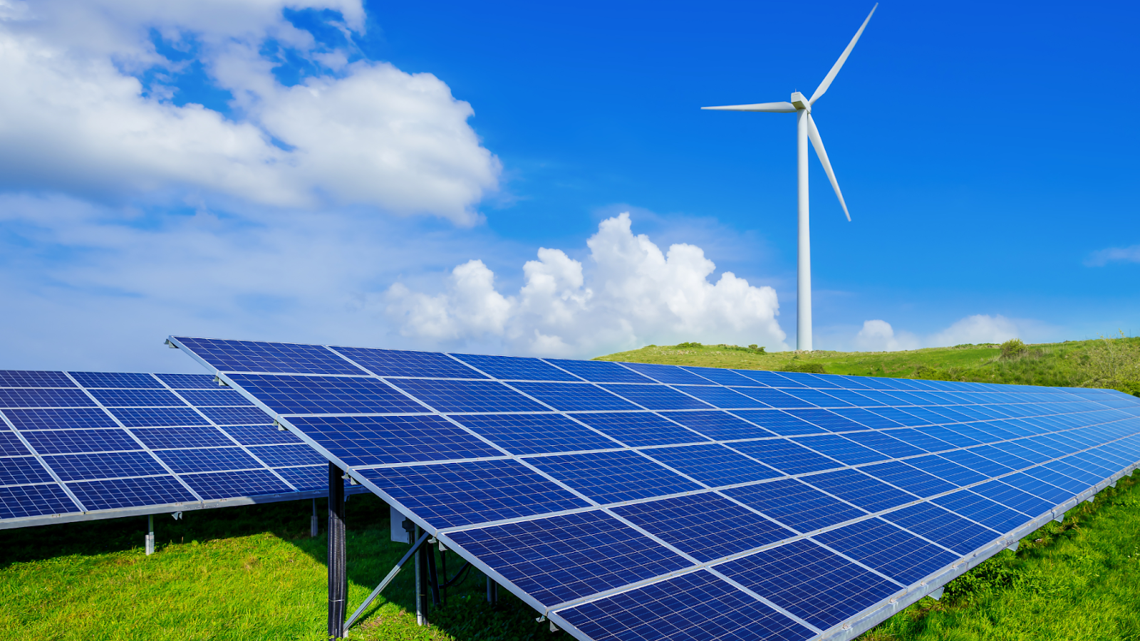 solar panels with wind turbine in the background